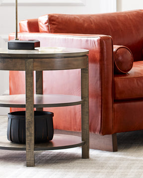 Origins by Stickley round end table next to red leather couch